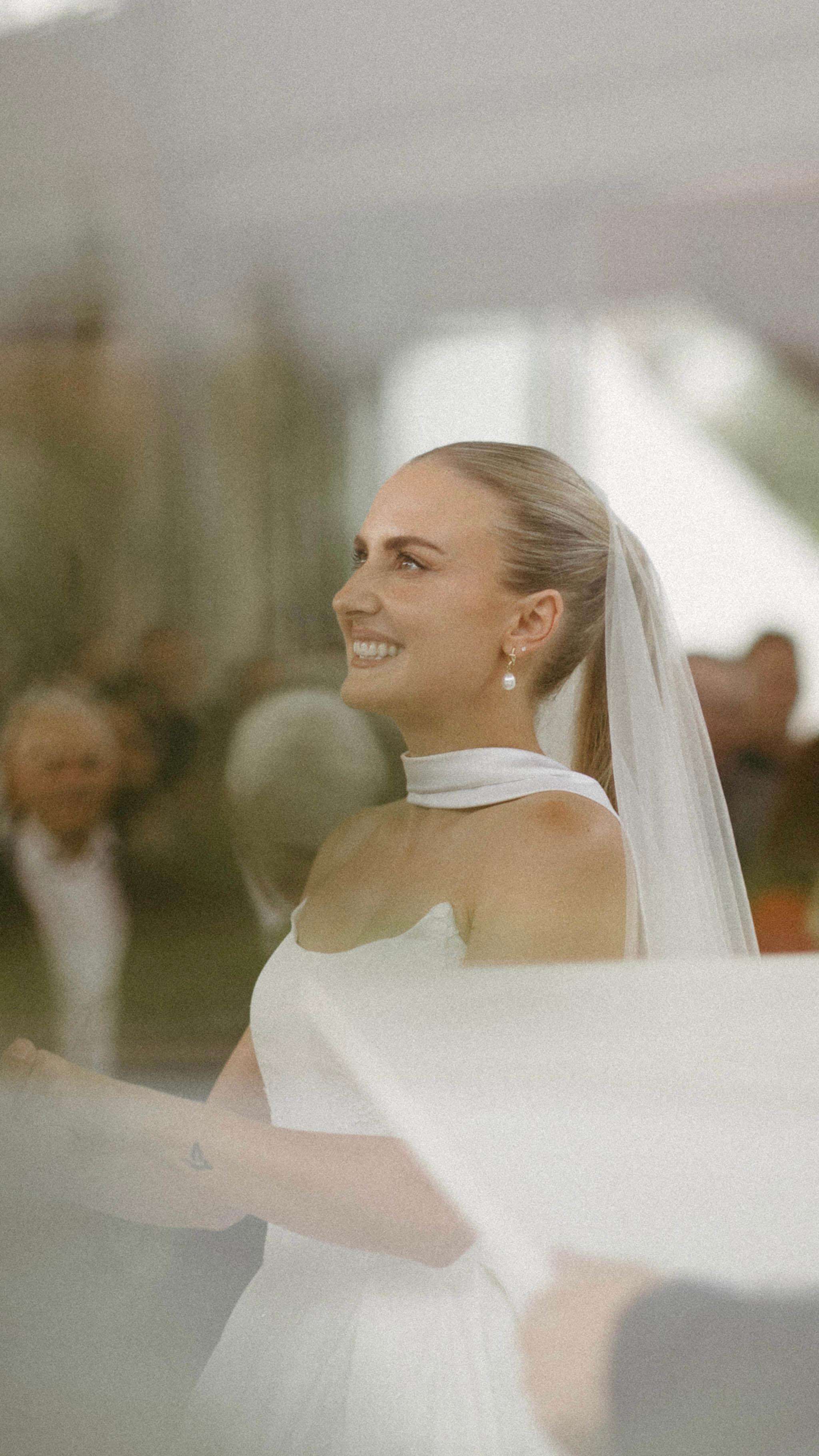Radiant bride smiling with flowing veil